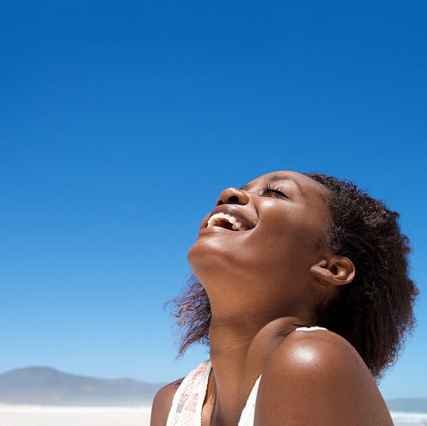 Girl with beautiful skin smiling in the sunshine.